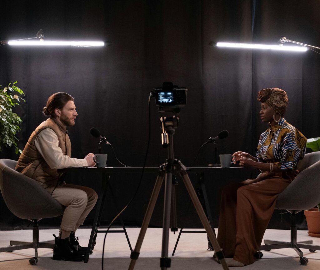 Dynamic podcast session featuring two hosts with studio lighting and recording equipment.